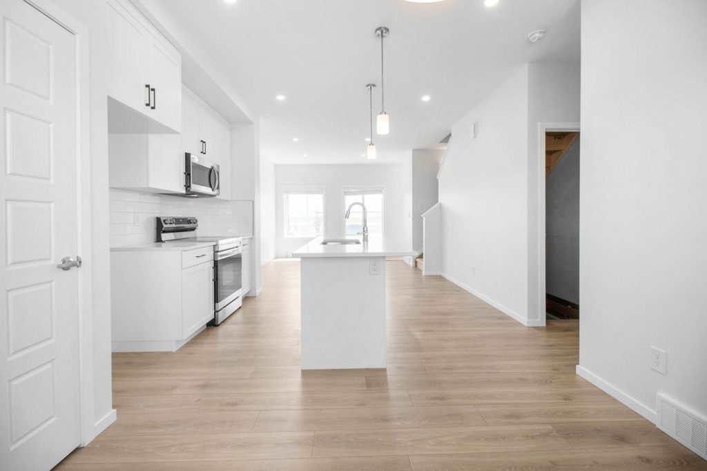 Open airy kitchen with stainless microwave and range and large island