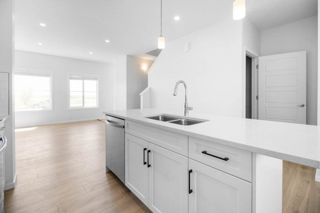 Quartz island with double basin sink, built-in dishwasher, and eating bar